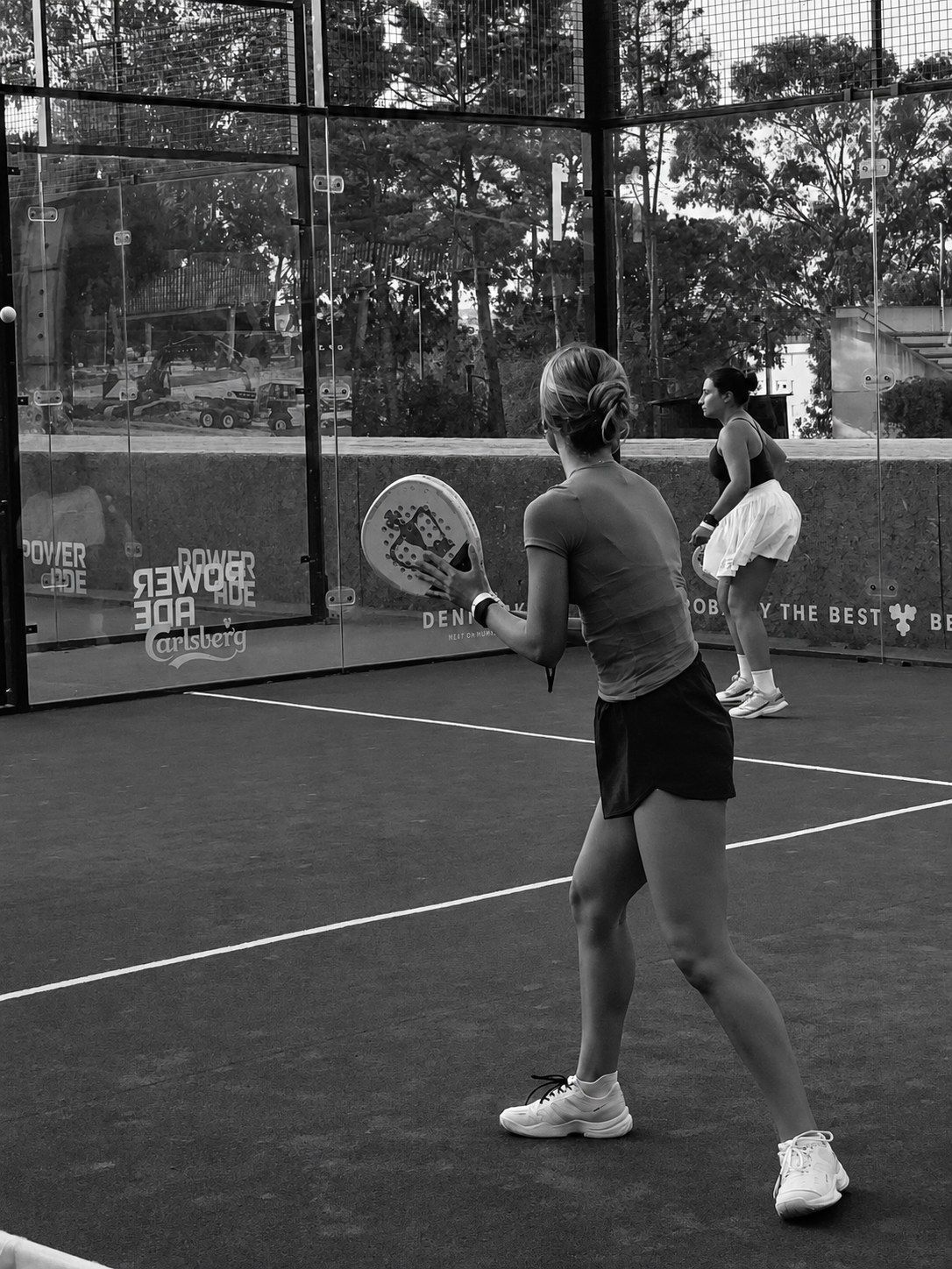 Two women playing padel